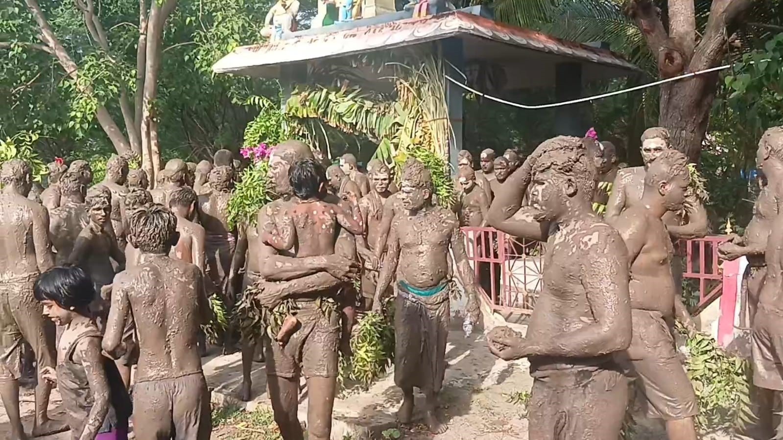 உடலில் சேற்றை பூசி   பக்தர்கள் நேர்த்தி கடன் 