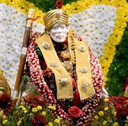 மலர்கள் மற்றும் தங்கக் காசுகளால் அலங்கரிக்கப்பட்டிருந்த சாயிபாபா